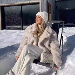 Chic beige faux shearling teddy jacket worn by model in a snowy outdoor setting