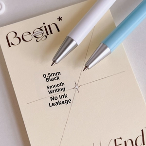 Detail of 0.5mm black ink retractable gel pen tip on minimalist paper notebook