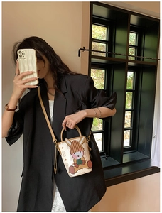 Model wearing a beige bucket bag with cartoon rabbit and cute animal prints