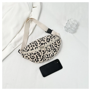 Detail of leopard print straw fanny pack with canvas strap and plastic buckle