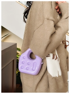Detail of purple PVC jelly bag with textured dots and stylish metal chain strap