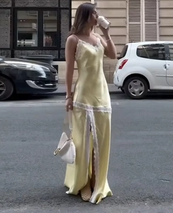 Gelbes Satin-Maxikleid mit weißem Spitzenbesatz und hohem Seitenschlitz im Detail