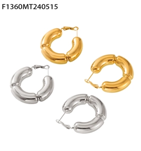 Close-up of hollow bamboo style C-shaped hoop earrings in polished gold and silver steel