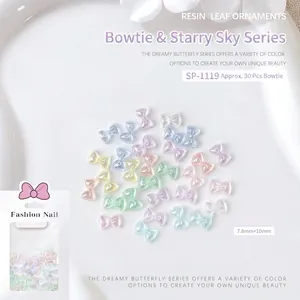 Macro shot of 7.6x10mm aurora resin bow nail charms in various macaron colors with glitter