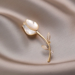Elegante tulpbroche met natuurlijke schelpenblaadjes en gouden details op zijde