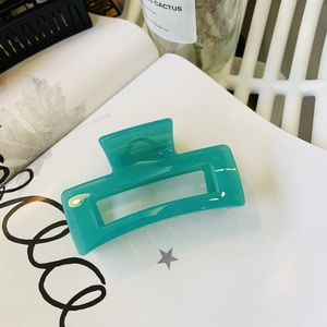 Detailed close-up of a mint green rectangular hollow acrylic hair claw clip on a white background