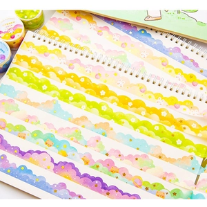 Detail of colorful cloud and star washi tape applied on a journal page with wavy edges