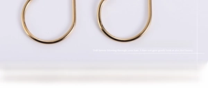 Close-up of polished 18K gold-plated infinity loop earrings with smooth metallic finish