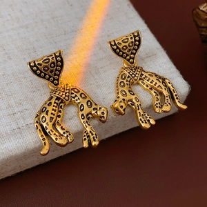 Detailed view of vintage gold leopard head earrings with textured leopard print design