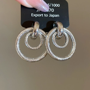 Détails de boucles d'oreilles argentées multicouches avec anneau texturé et face lisse