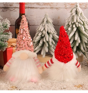 Detail of pink and red sequined Christmas gnomes with white faux fur beards in snow scene