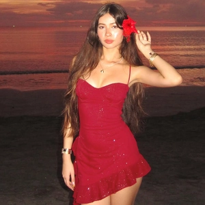 Close-up of red sequined bodycon dress with ruffle hem on a sunset beach