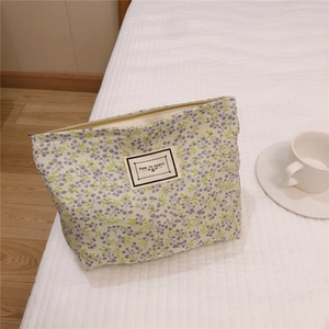 Detail of floral canvas makeup bag with purple flower patterns and metallic zipper