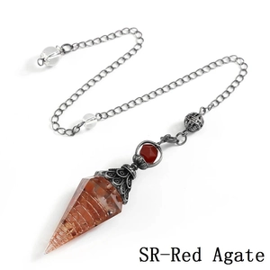 Macro detail of red agate crystal resin pendulum with antique silver metal spiral