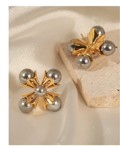 Detail of vintage copper stud earrings with gray pearls on silk and stone background
