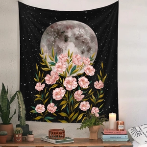 Detail of moon phase tapestry with pink cherry blossoms in a cozy bohemian room setting