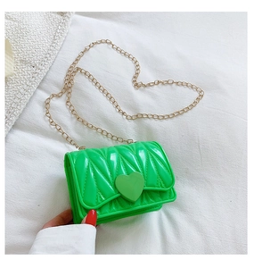 Detail of neon green mini crossbody bag with heart lock and gold chain strap