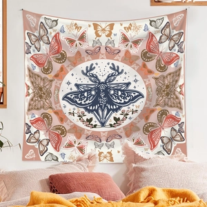 Detail of bohemian wall tapestry featuring central moth and floral moth patterns in soft pink