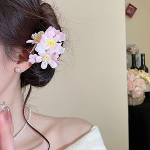 Close-up detail of three pink fabric cherry blossom hair pins with yellow stamens
