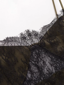 Détail de robe en satin vert foncé avec dentelle de cils noire et finitions délicates
