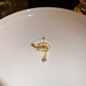 Detail view of gold-plated triple-layer heart ear cuff with pearls and chain tassels