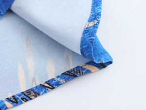 Dettaglio ravvicinato del tessuto con stampa floreale blu e cuciture dell'abito lungo