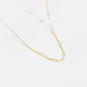 Elegant gold-tone beaded necklace with white pearls on a minimalist chain for women