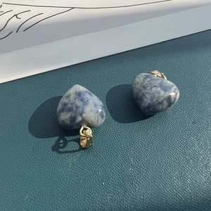 Detailed macro of two heart-shaped natural blue stones with golden metal clasps