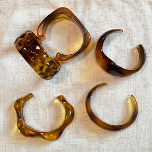 Set of four amber acrylic irregular geometric bangles with retro translucent resin finish