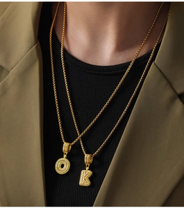 Fashionable golden letter O and K pendants with cubic zirconia on model neck