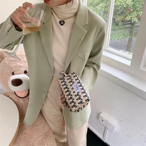 Détail de la trousse de maquillage en velours à fleurs avec étiquette et poignée beige