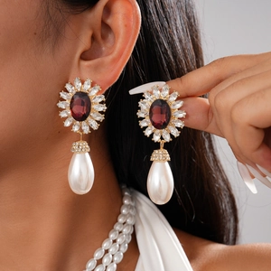 Boucles d'oreilles vintage avec pierres rouges et perles blanches sur modèle élégant