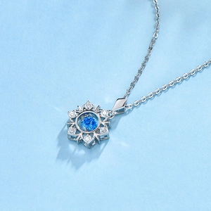 Close-up of S925 silver snowflake necklace with a blue central stone and micro-inlaid zircons
