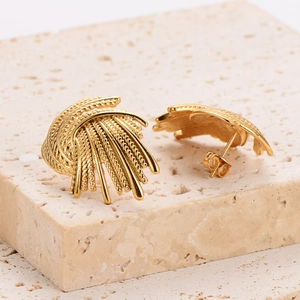 Golden irregular vortex swirl earrings with feather-like texture on a stone base
