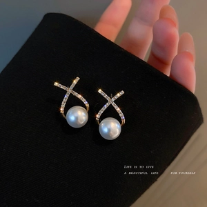 Elegant gold X-shaped earrings with micro-pave diamonds and large white pearls