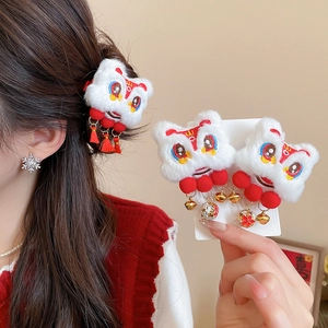 Détail de la pince à cheveux lion du Nouvel An avec peluche blanche et pompons rouges