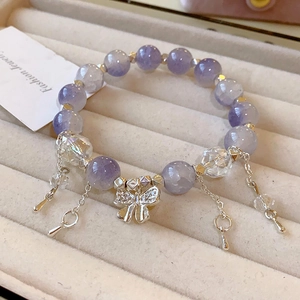 Mehrlagiges lila Perlenarmband mit silbernem Schmetterlingsanhänger und Metallquasten