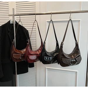 Detailed view of glossy vintage shoulder bags with flap pockets and silver metal buckles