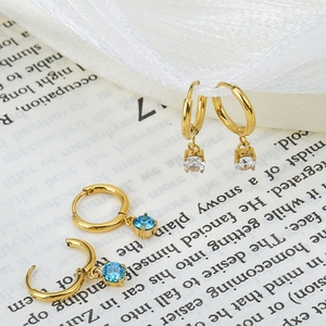 Elegant gold zircon drop earrings with sky blue and clear stones on vintage paper background