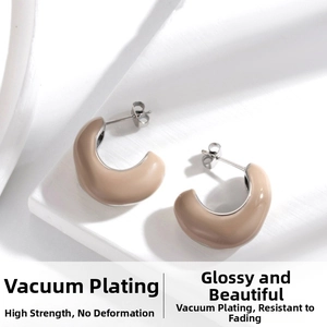 Detail of C-shaped hoop earrings with light brown enamel finish and polished steel interior