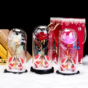 Three glass dome Christmas ornaments with colorful roses, LED lights, and gift bags