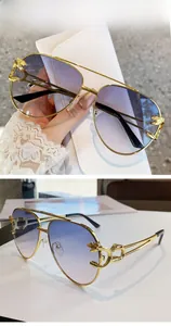 Detail of golden leopard head emblem on pilot sunglasses with blue gradient lenses