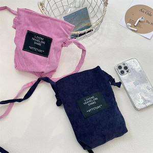 Detailed corduroy texture of pink and blue mini crossbody bags on a white surface