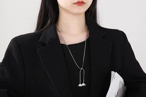Detail of adjustable silver snake chain featuring double elephant pendants on a black blazer