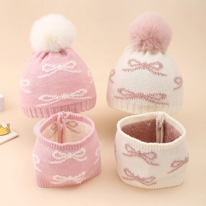 Detailed view of baby knit hat and scarf set with jacquard bow pattern and faux fur pom