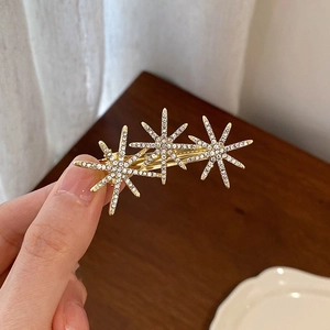 Elegant gold hair clip with three sparkling rhinestone stars for a luxurious vintage look