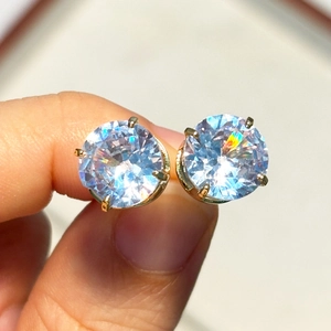 Detailed close-up of classic 4-claw gold plated stud earrings with round cubic zirconia