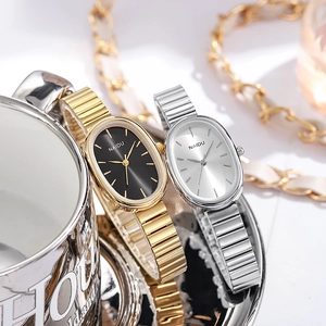 Detail of elegant gold and silver oval dial quartz watches with metallic chain straps