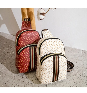 Close-up of stylish burgundy and beige waist bags with red-green striped woven straps