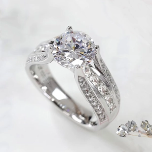 Macro shot of 4-claw round brilliant cut ring with hollow band and side stones